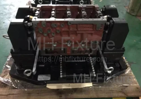 Multi-station hydraulic clamping jig for 4-cylinder diesel engine block processing on a 3-axis vertical machining center.